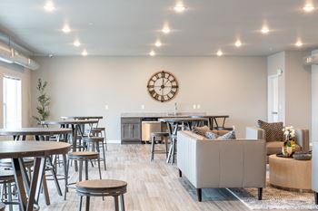 A clubhouse with tables and chairs and a large clock on the wall
